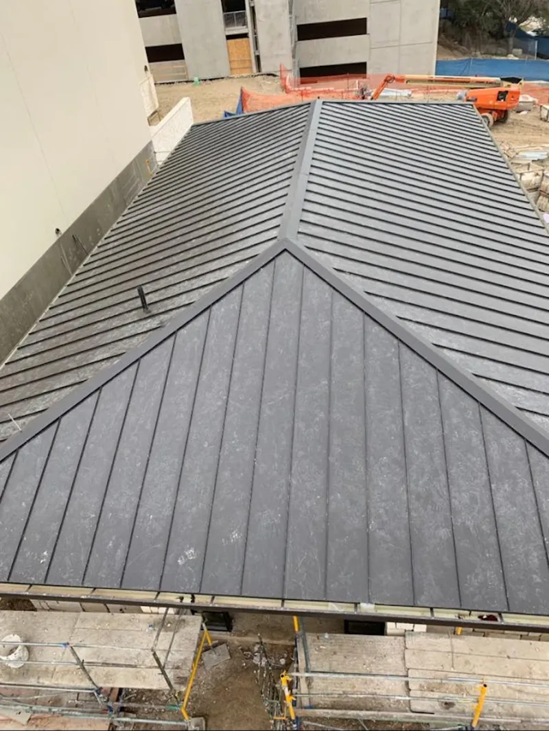 Commercial metal roof construction with crane equipment in Sanger